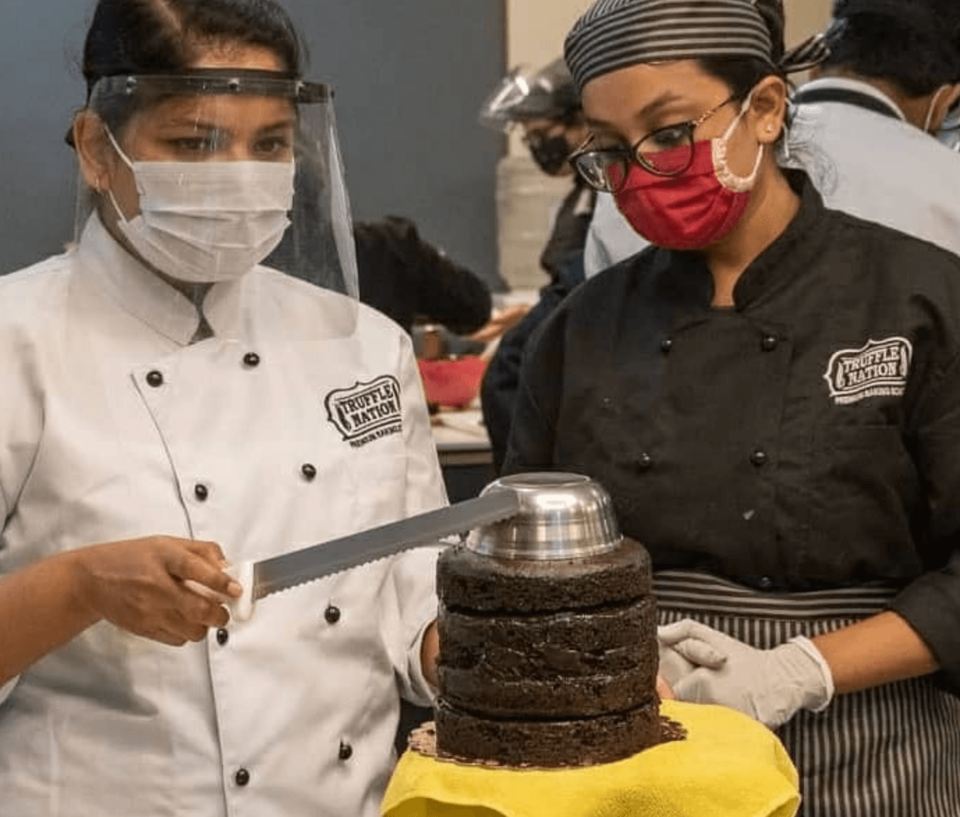 Chef team assembling a layered chocolate cake in the studio kitchen